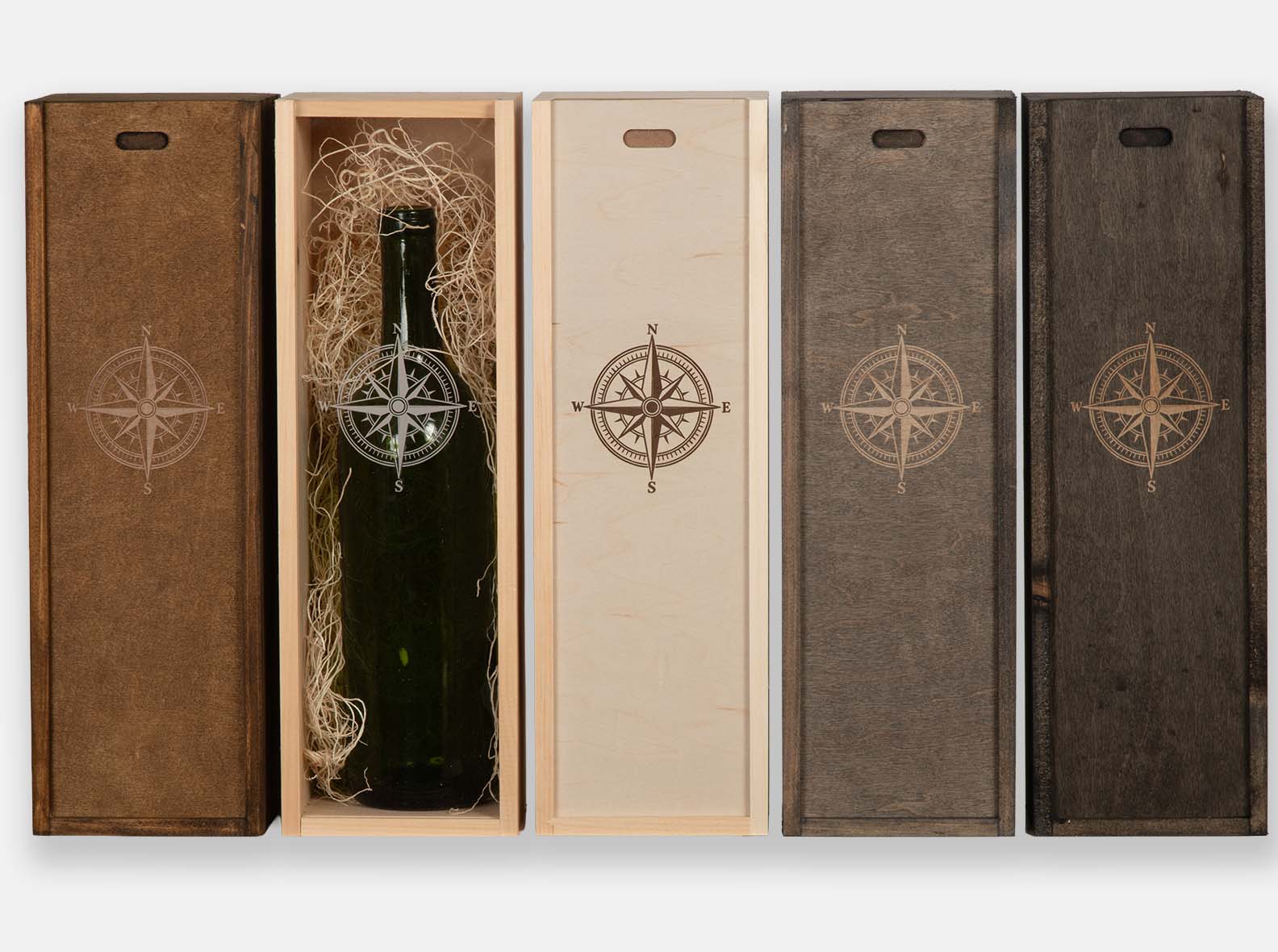 Five wooden wine boxes in different stains, each laser-engraved with a compass rose.